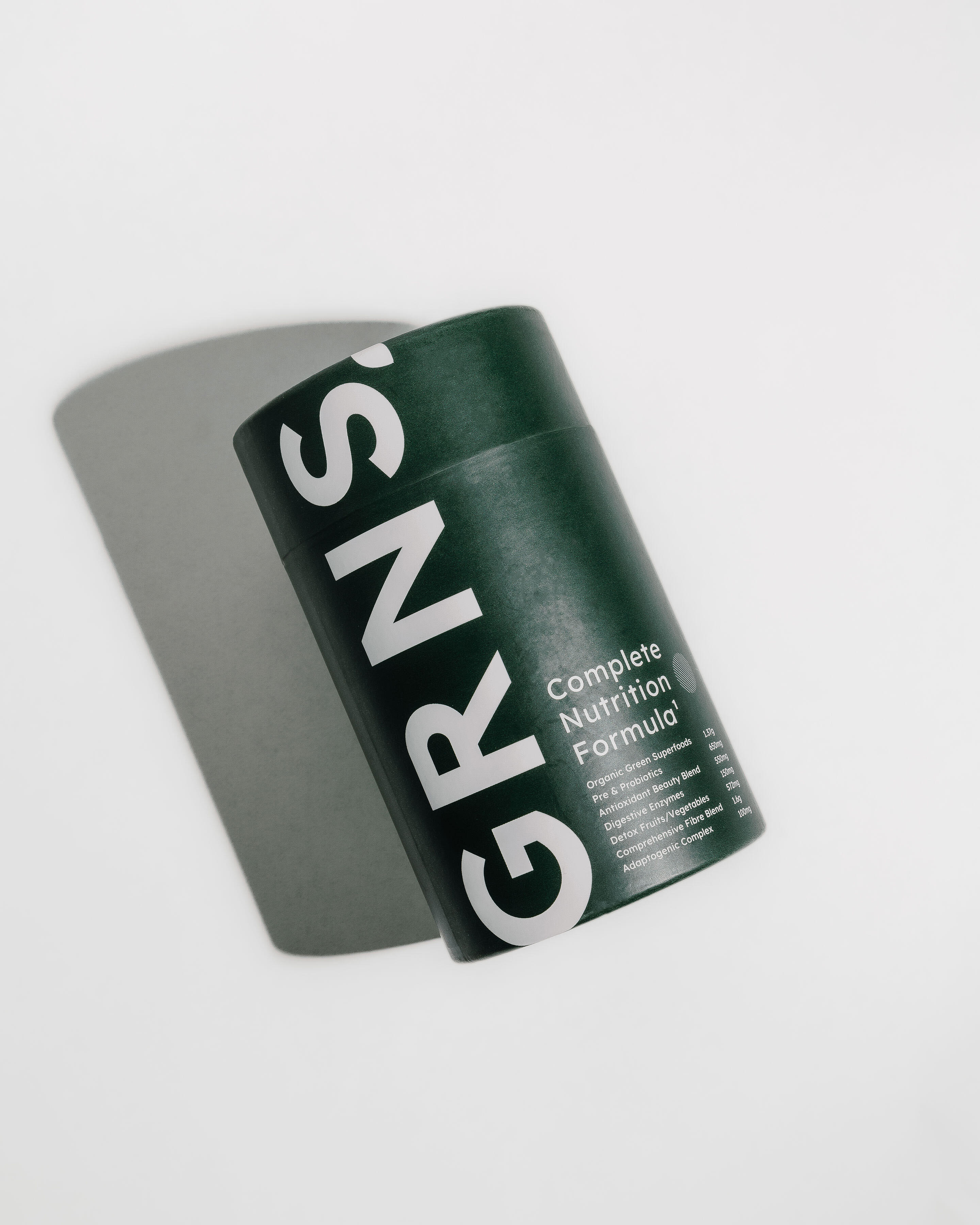 Flat-lay of GRNS Complete Nutrition Formula container on a white background, showcasing bold branding and simplicity