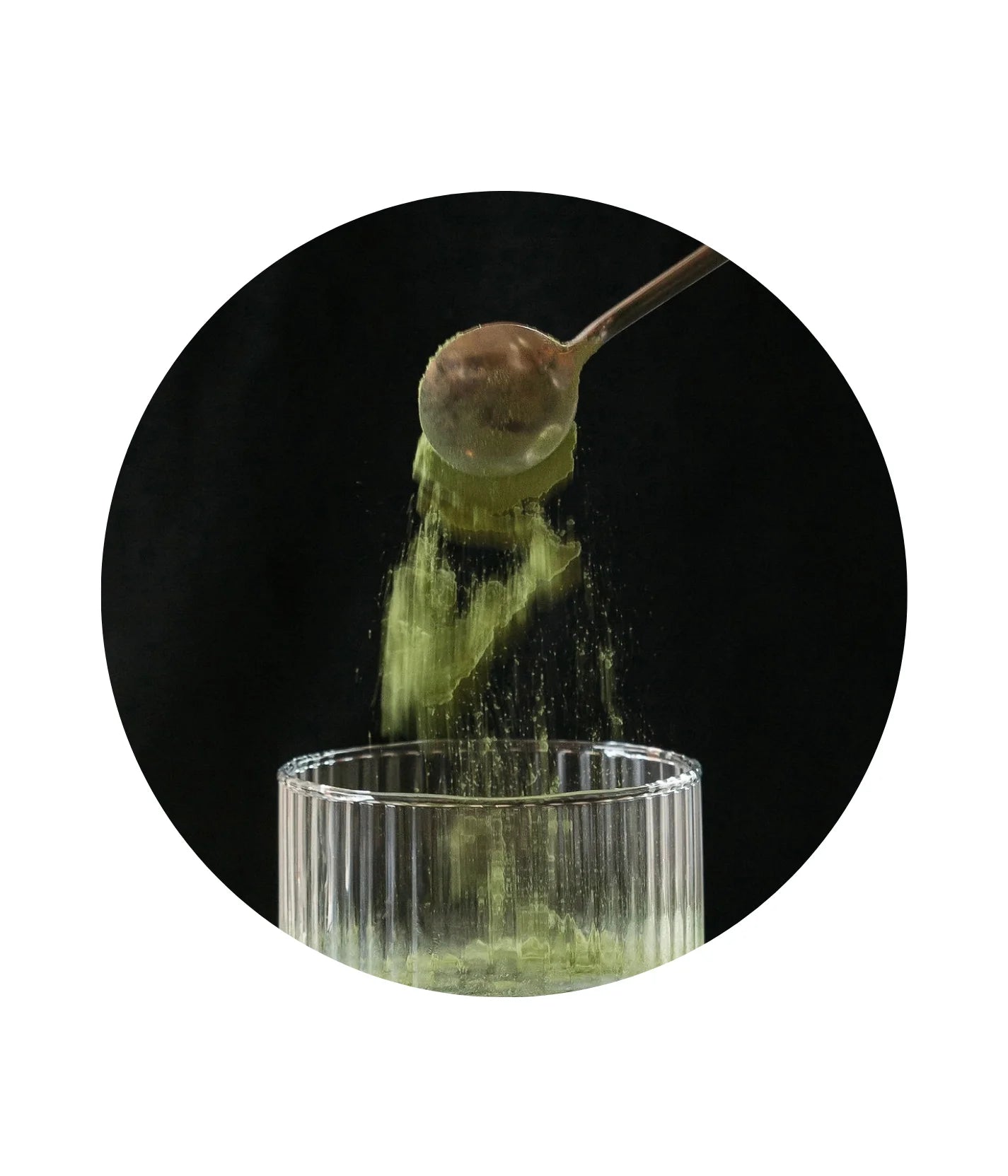 greens powder being poured into a glass of water