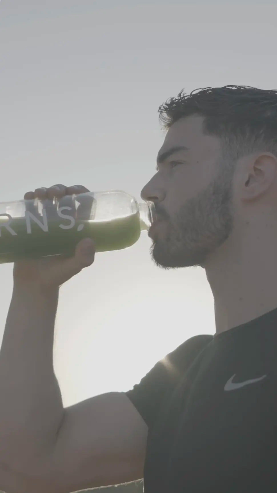 A guy drinking GRNS from a bottle