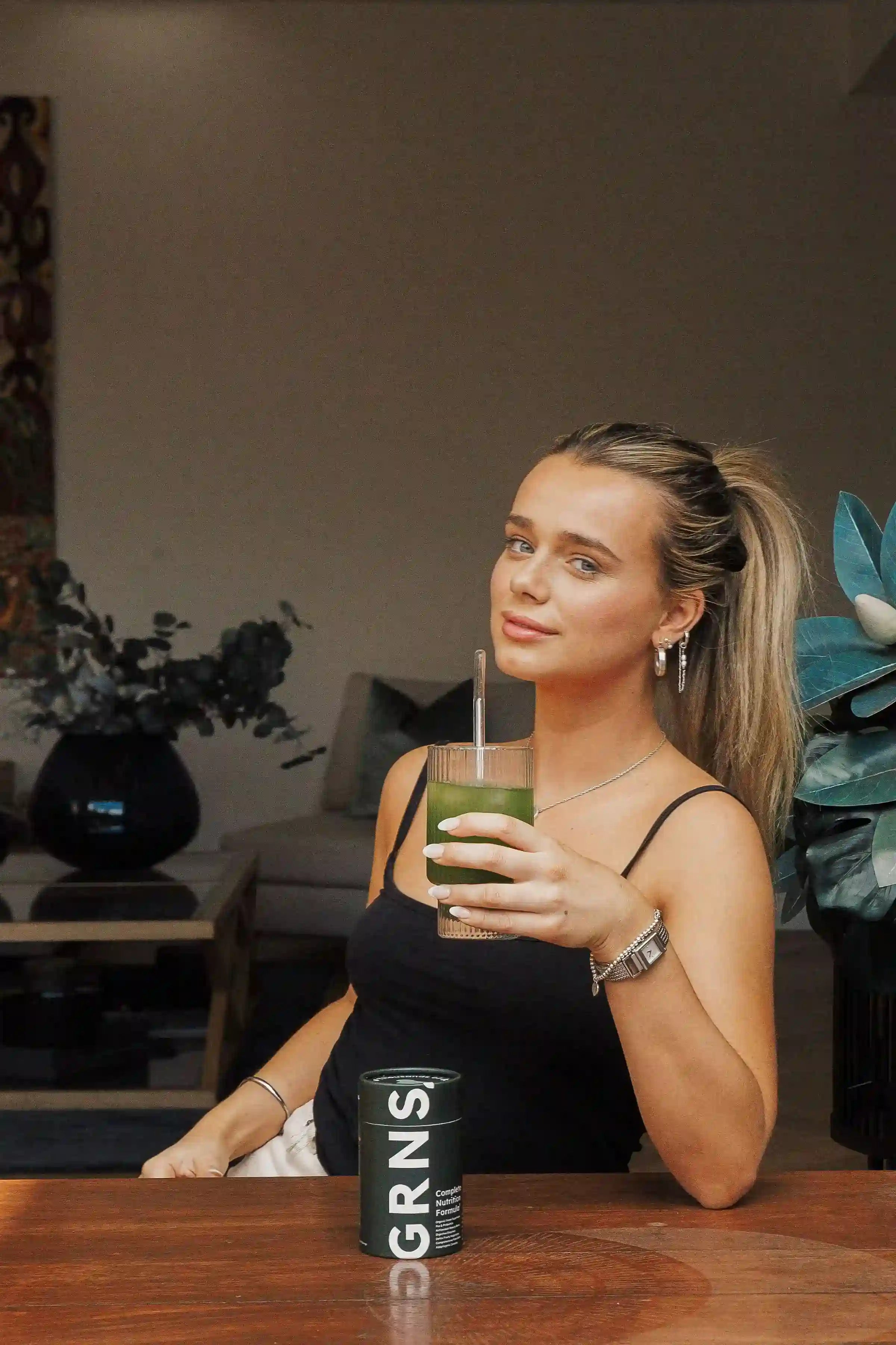 GRNS Hero A girl holding a glass of greens powder