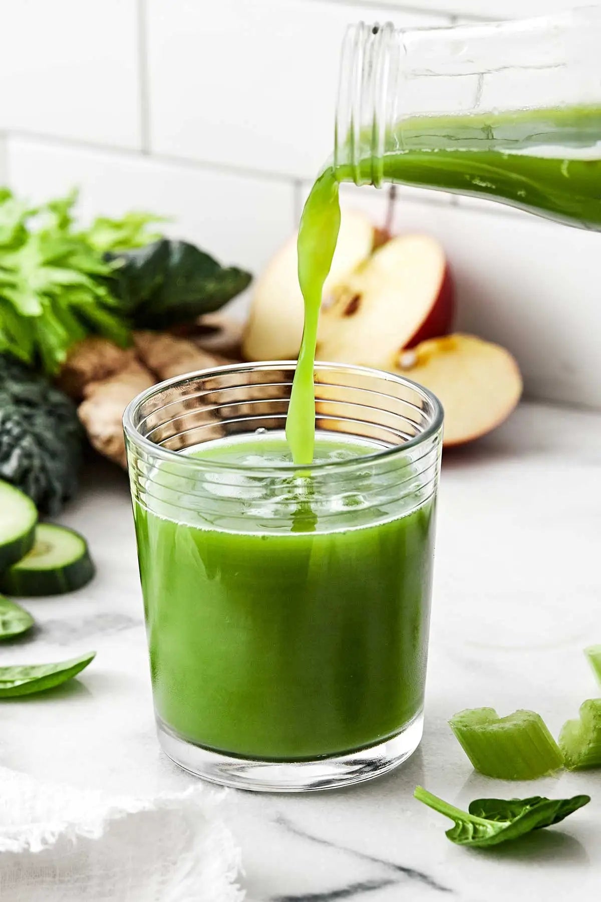 Green juice being poured into a glass