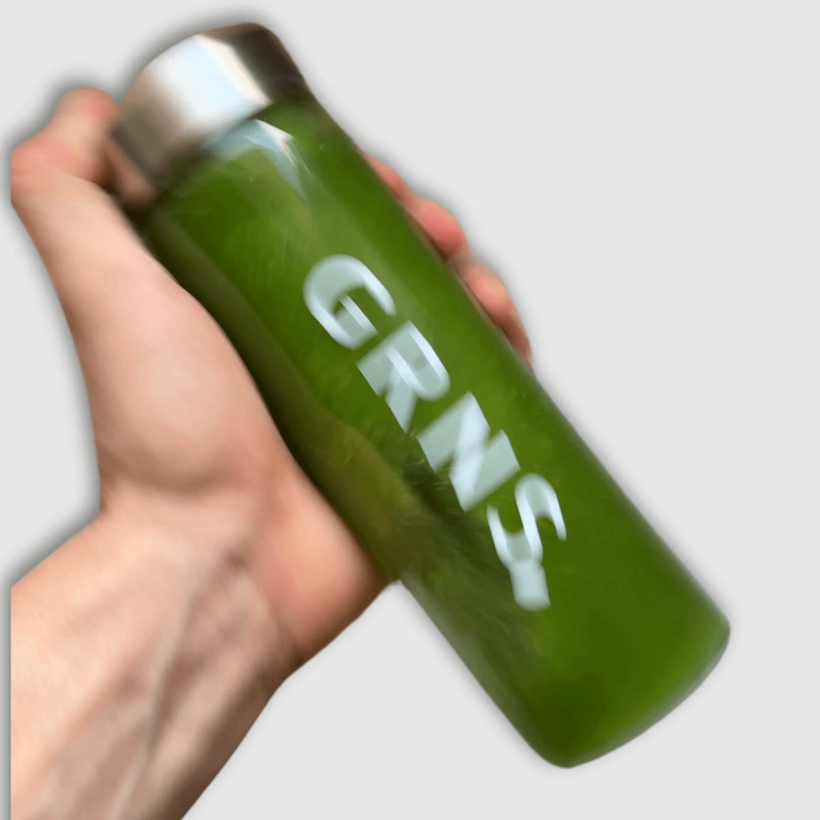 A bottle with greens powder supplement drink being shaken